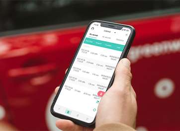 A hand holding a smartphone displaying error information logging for an electric vehicle charger, with a red car in the background.