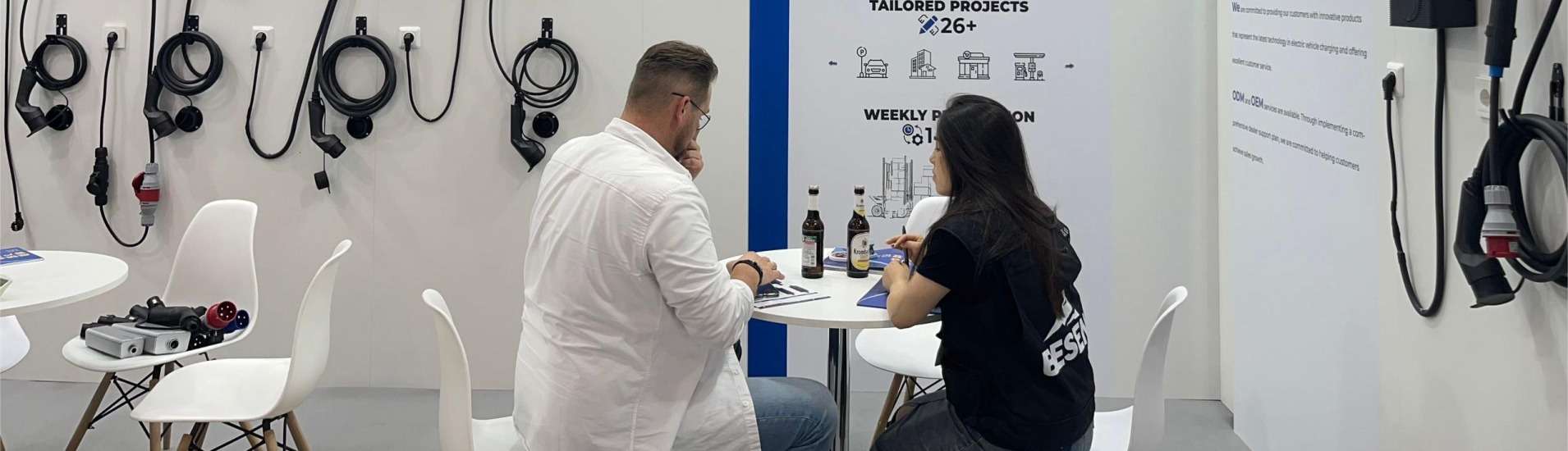 BESEN sales worker answering inquiries for a customer about EV charging stations at the Power2Drive expo.