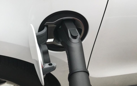 Close-up view of a BESEN Type 2 to GB/T charging cable connected to an electric vehicle's charging port.