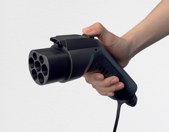 A person holding a black GB/T plug, showing the front view of the plug's multiple connectors.