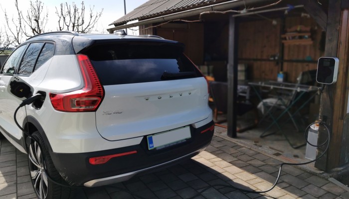 White Volvo XC40 Recharge plugged into BESEN BS20 electric vehicle wall charger in a garage